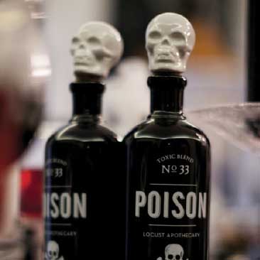 Black and White detail of 'poison' bottles with white ceramic skull toppers for a scary Halloween dinner party, Boston Event Planner, Boston Event Planning, Boston Event Stylist, Boston Event Styling