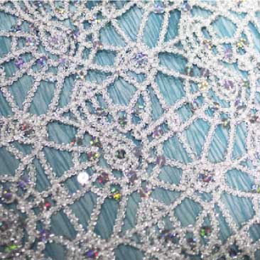 Blue detail of glitter-encrusted and bejeweled lace tablecloth for a corporate holiday event, Boston Event Planner, Boston Event Planning, Boston Event Stylist, Boston Event Styling