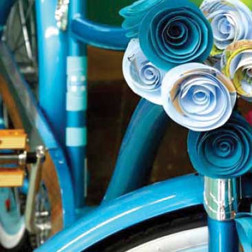 Blue detail of quilled flowers decorating an old-fashioned bicycle for a travel-themed corporate celebration, Boston Event Planner, Boston Event Planning, Boston Event Stylist, Boston Event Styling