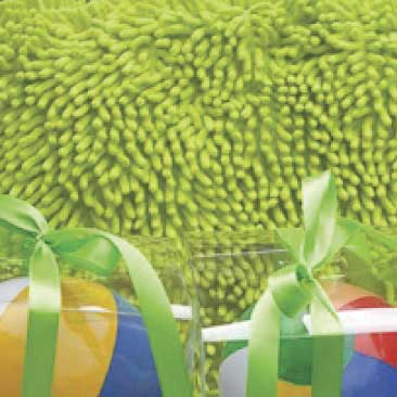 Green detail of miniature beach ball goodies for a backyard birthday pool party sitting stacked against lime green pillows; Boston Event Planner, Boston Event Planning, Boston Event Stylist, Boston Event Styling